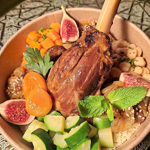 Bol de couscous à la souris d'agneau, carottes, courgettes et figue