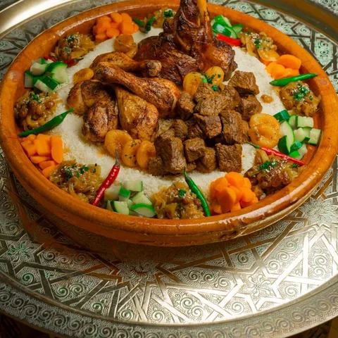 Couscous royal servi sur un plateau en cuivre ciselé